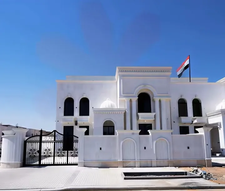 مبنى مدارس الارتقاء الأبيض والعلم العراقي فوقه