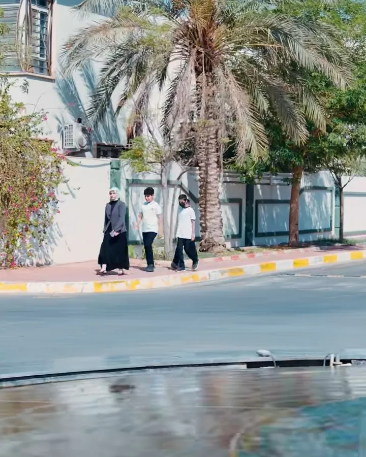 نخيل ونافورة وطلاب يسيرون في المجمع